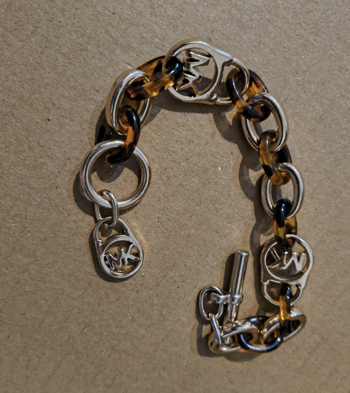 Michael Kors Silver Tone Oval Link Toggle Bracelet w/ Brown Dangle Logo Charms
