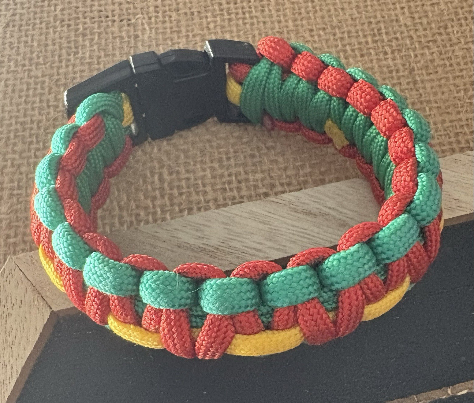 multicolor braided paracord bracelet . adjustable 8 in . black plastic buckle