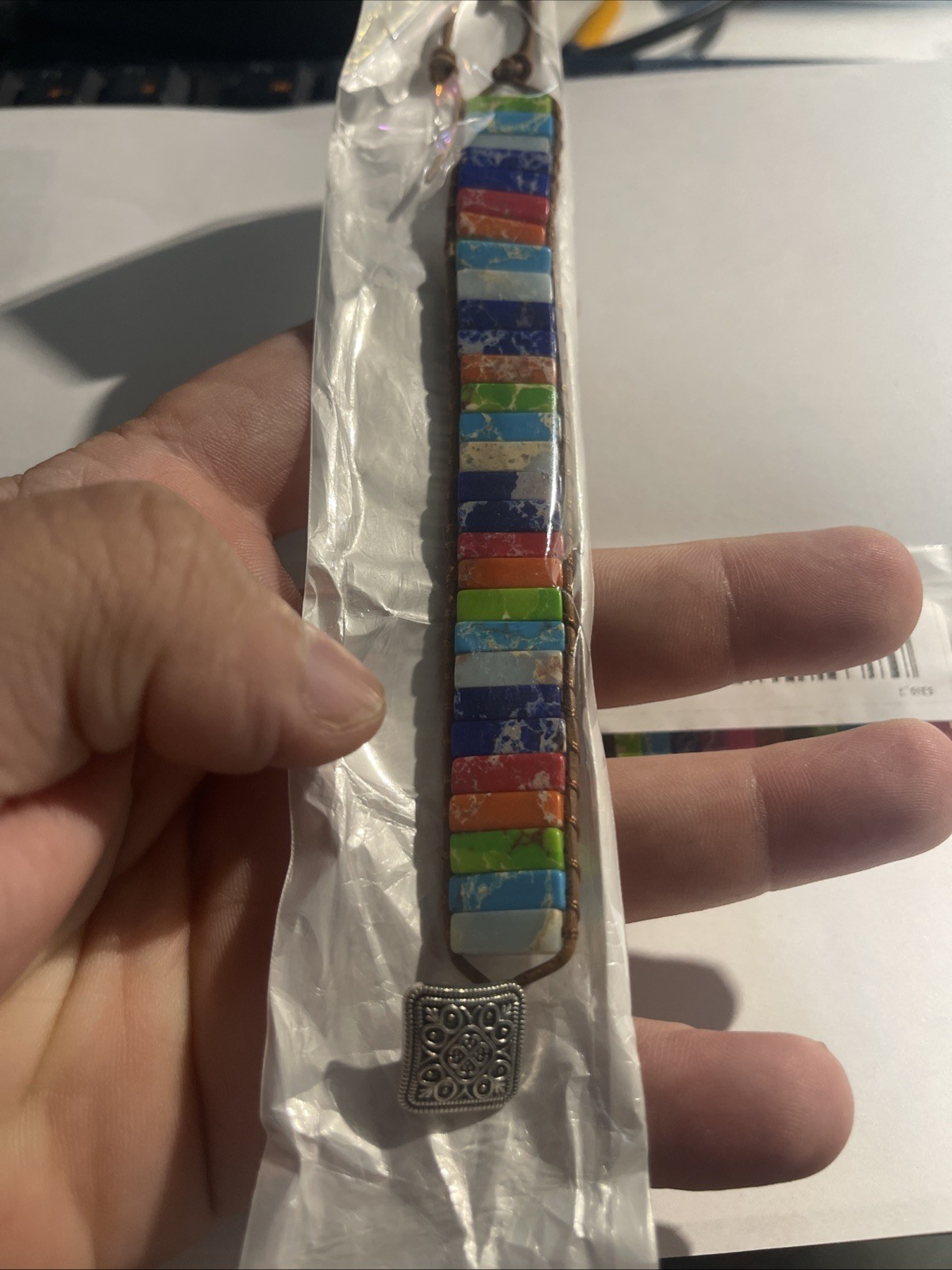 Set of 2 multicolored stone bracelets with leather cord and metal clasp.