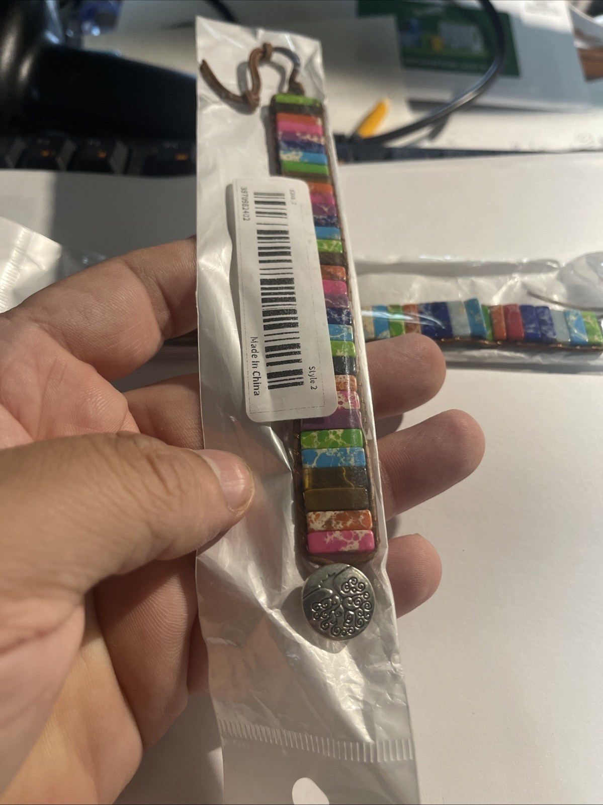Set of 2 multicolored stone bracelets with leather cord and metal clasp.