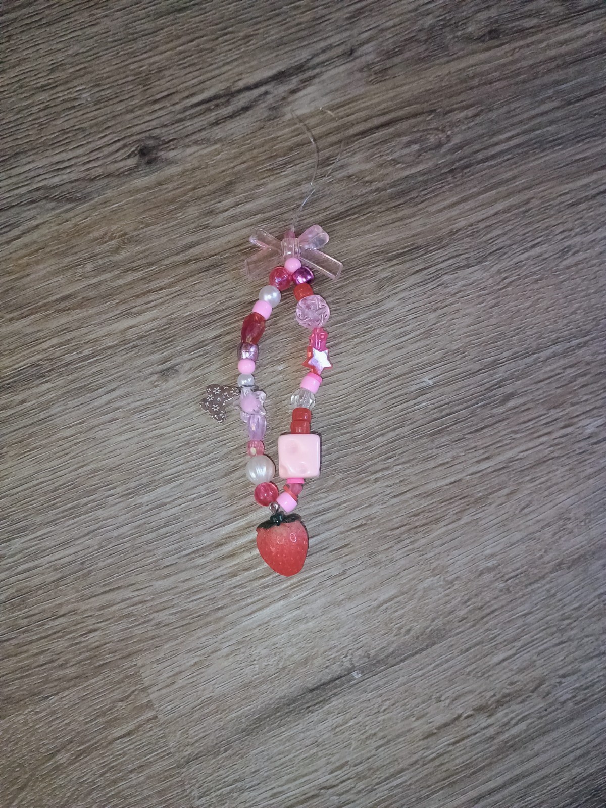 Pink strawberry phone charm with bow on top with red,white, pink beads