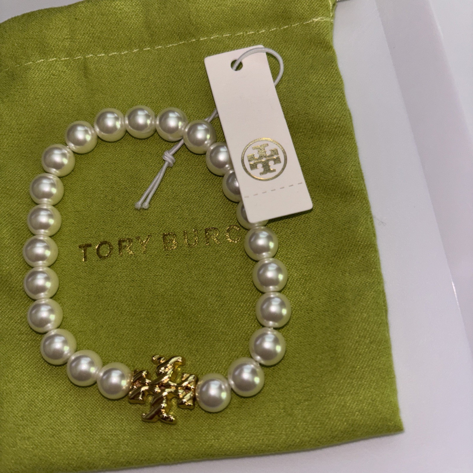 Tory Burch Pearl Bracelet with gold Kira logo.