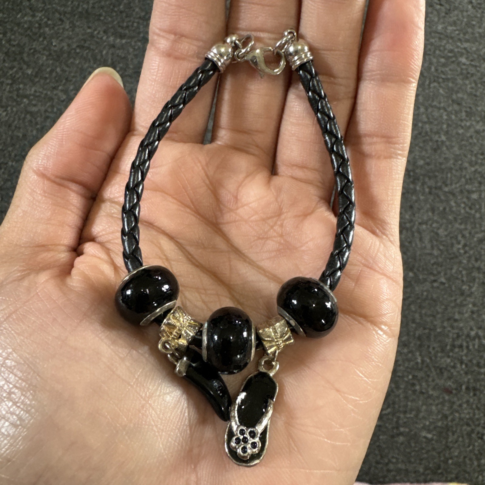 Bracelet black braided cord, silver tone charms, toggle clasp
